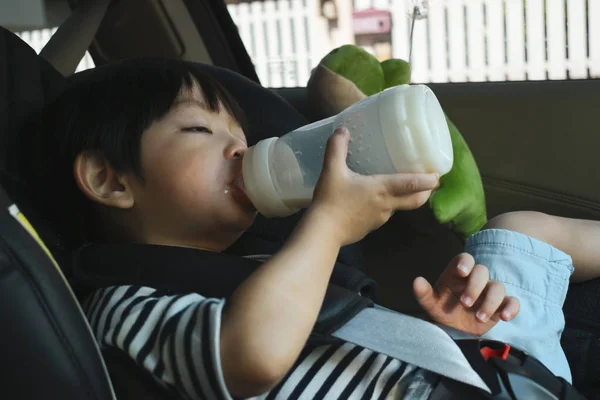 Bayi laki-laki mengisap susu pada drive keselamatan kursi mobil — Stok Foto