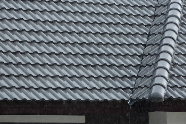 Chuva tempestade despeje na telha do telhado preto da casa residencial — Fotografia de Stock