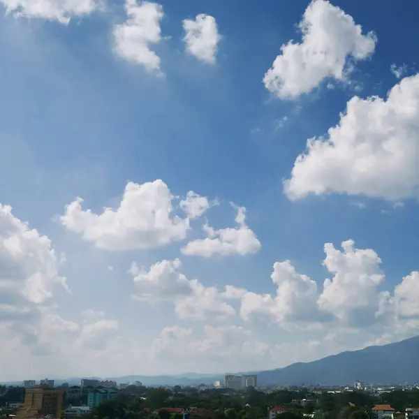 Nuvem branca no céu azul claro acima da cidade — Fotografia de Stock