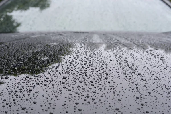 Gota de lluvia de agua en el coche moderno vehículo negro con recubrimiento de vidrio — Foto de Stock