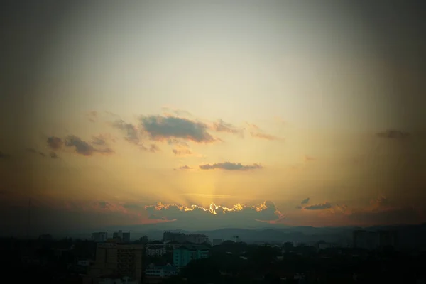 Şehrin üzerinde gün batımı gökyüzünde güneş ışığı — Stok fotoğraf