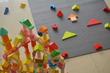 Evde kalıp oyun oynayan çocuklar için renkli tahta blok geometrik oyuncaklar.
