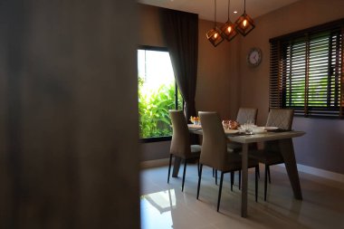 Çanak çömlek takımı yemek masasının üzerinde modern ev içi yemek odasının içinde.