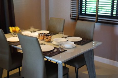 Çanak çömlek takımı yemek masasının üzerinde modern ev içi yemek odasının içinde.