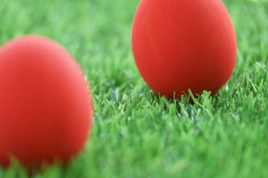 Çimenlikteki kırmızı paskalya yumurtası yeşil çimenler suni, bahar sabahı konsepti.