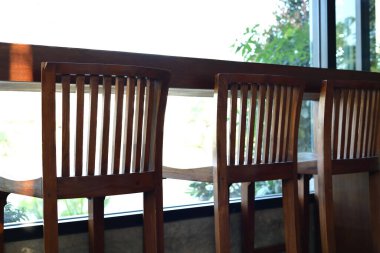Kafenin içinde ahşap sandalye ve masa barı var.