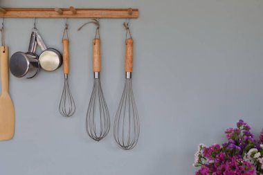 Mutfak odasındaki duvarda mutfak malzemeleri asılı.