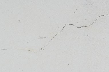 Yıpranmış arka planda eski beyaz duvarda çatlak var.