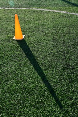 Yapay yeşil çimen futbol sahası ve turuncu eğitim konileri