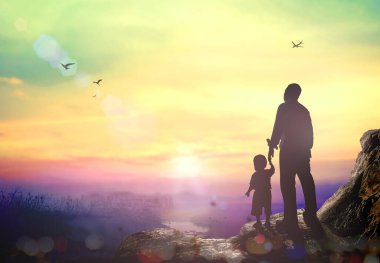 Uluslararası İnsan Hakları Günü konsepti: Baba ve oğlu sonbahar gündoğumu arka planında dağın tepesinde