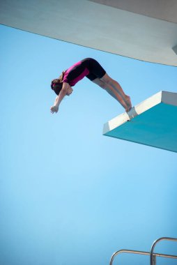 Kafkas kadın 8 yaşında neopren kısa sörf kıyafeti giyen kız 5 mether dalış platformundan dalıyor. Yaz, spor ve eğlence konsepti.
