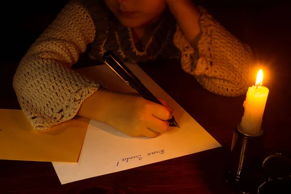 Little caucasian girl writing a letter for Santa Claus.
