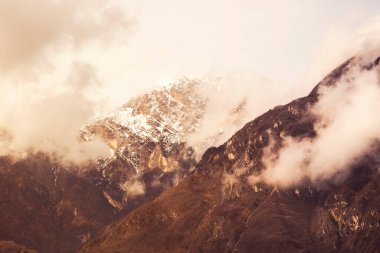 Karla kaplı Alp dağlarına yağmur bulutları yağıyor.