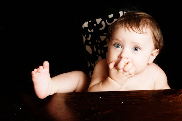 子供に餌をやる 食事で面白い赤ちゃんパン地殻を食べる 黒の背景にクローズアップ写真 スペースのコピー — ストック写真