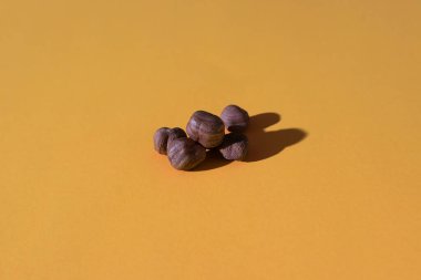 Turuncu arka planda soyulmuş fındık demeti; sert ışıklı fotoğraf