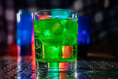 Votka cin, rom, tekila ve renkli ışıkları olan bir gece kulübündeki bir barda buzlu kokteyl.