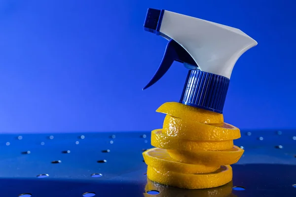 air freshener and window cleaner and lemon on a metal surface on a blue background