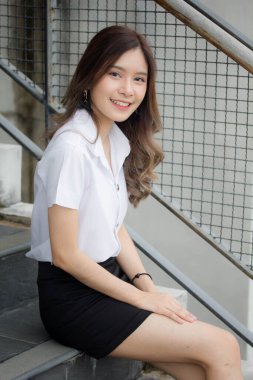 Taylandlı yetişkin öğrenci üniforması portresi. Güzel kız rahatla ve gülümse.