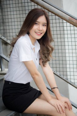 Taylandlı yetişkin öğrenci üniforması portresi. Güzel kız rahatla ve gülümse.