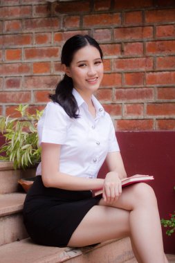 Taylandlı yetişkin öğrenci üniforması portresi. Güzel kız rahatla ve gülümse.