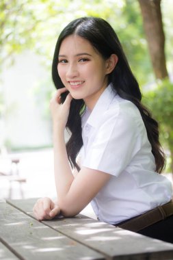 Taylandlı yetişkin öğrenci üniforması portresi. Güzel kız rahatla ve gülümse.