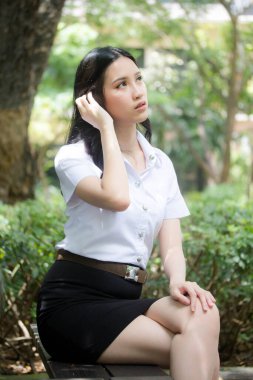 Taylandlı yetişkin öğrenci üniforması portresi. Güzel kız rahatla ve gülümse.