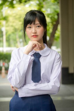 Taylandlı liseli üniformasının portresi. Genç güzel kız mutlu ve rahat.