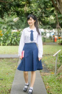 Taylandlı liseli üniformasının portresi. Genç güzel kız mutlu ve rahat.