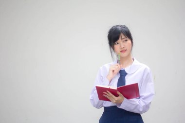 Asya Thai Lisesi üniformalı güzel kız. Bir kitap yaz.