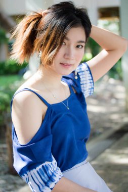 Beautiful young adult thai chinese blue tank top relax and smile