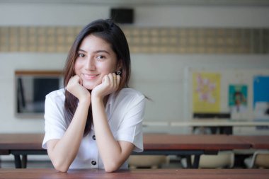 Taylandlı yetişkin öğrenci üniforması portresi. Güzel kız rahatla ve gülümse.