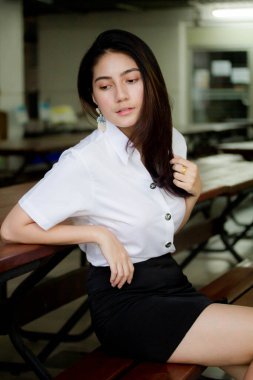 Taylandlı yetişkin öğrenci üniforması portresi. Güzel kız rahatla ve gülümse.