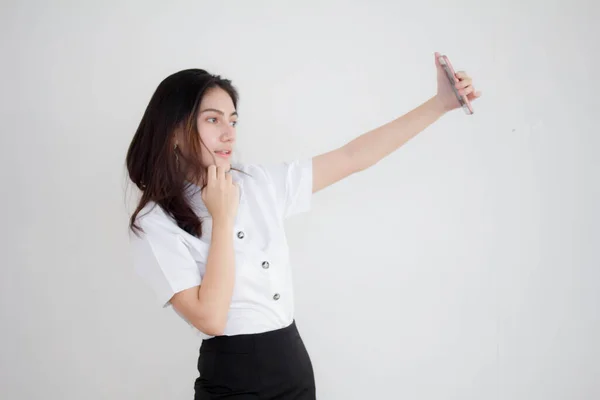 タイのポートレート大人学生大学制服美しいです女の子使用して彼女のスマートフォンSelfie — ストック写真