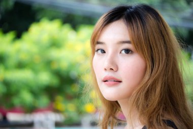 Beautiful young adult thai chinese bronze hair relax and smile