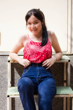 Taylandlı yetişkin portresi. Güzel kırmızı gömlek. Rahatla ve gülümse.