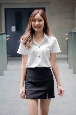 Taylandlı yetişkin öğrenci üniforması portresi. Güzel kız rahatla ve gülümse.