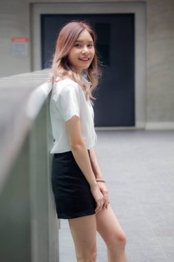 Taylandlı yetişkin öğrenci üniforması portresi. Güzel kız rahatla ve gülümse.