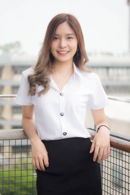 Taylandlı yetişkin öğrenci üniforması portresi. Güzel kız rahatla ve gülümse.