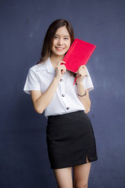 Taylandlı yetişkin öğrenci üniforması portresi. Güzel kız kırmızı kitabı okudu.