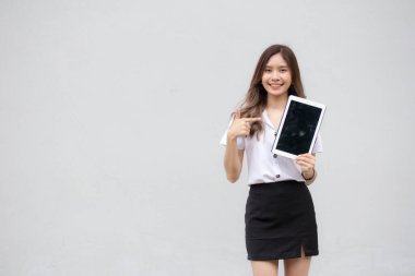 Portrait of thai adult student university uniform beautiful girl show her tablet.