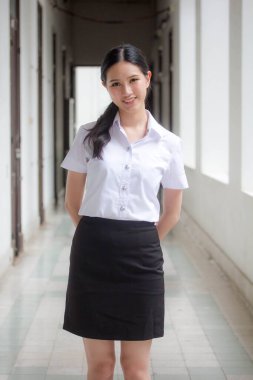 Taylandlı yetişkin öğrenci üniforması portresi. Güzel kız rahatla ve gülümse.