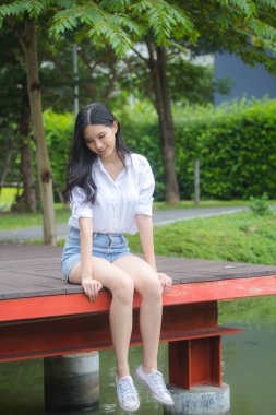 Tayland portresi yetişkin güzel kız beyaz gömlek mavi kot rahatla ve gülümse