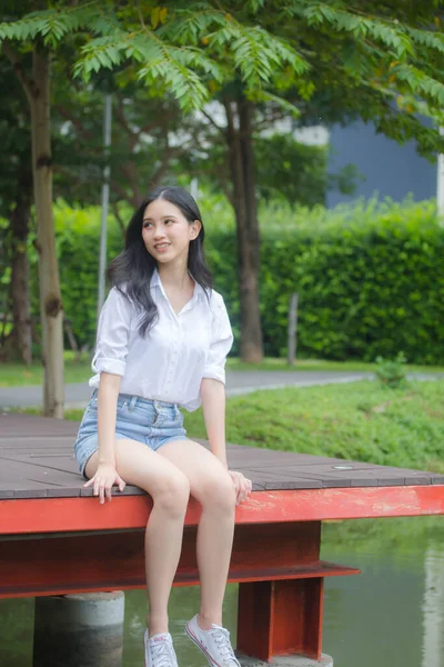 タイの肖像中国大人の美しい女の子白いシャツ青いジーンズリラックスして笑顔 — ストック写真