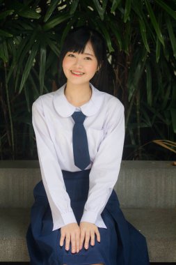 Taylandlı liseli üniformasının portresi. Genç güzel kız mutlu ve rahat.