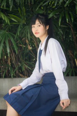 Taylandlı liseli üniformasının portresi. Genç güzel kız mutlu ve rahat.