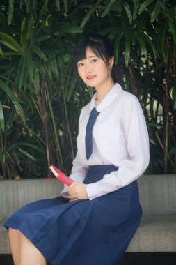 Taylandlı liseli üniformasının portresi. Genç güzel kız mutlu ve rahat.