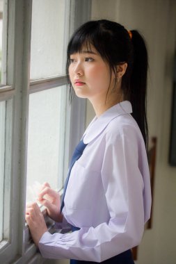 Taylandlı liseli üniformasının portresi. Genç güzel kız mutlu ve rahat.