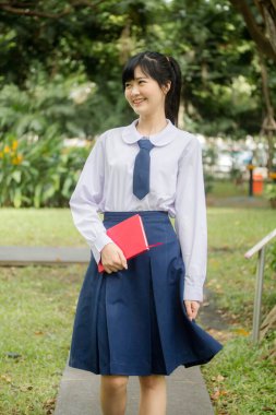 Taylandlı liseli üniformasının portresi. Genç güzel kız mutlu ve rahat.