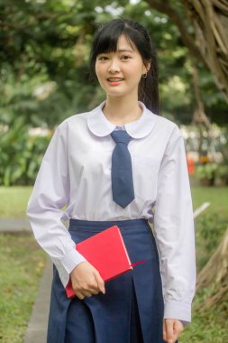 Taylandlı liseli üniformasının portresi. Genç güzel kız mutlu ve rahat.