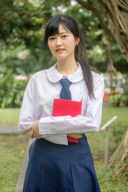 Taylandlı liseli üniformasının portresi. Genç güzel kız mutlu ve rahat.